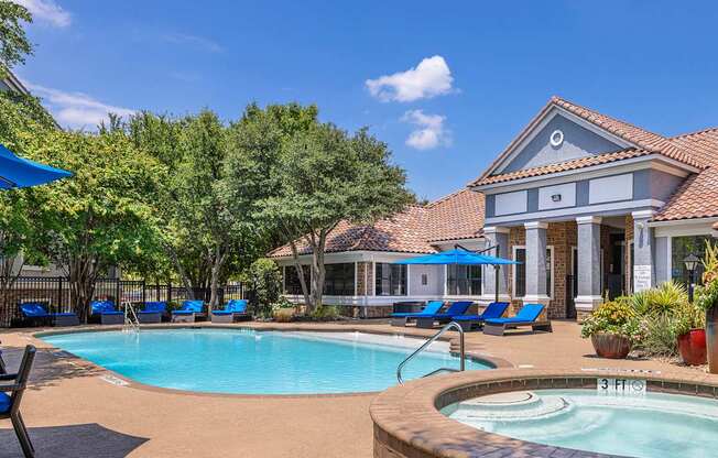 A pool with a hot tub in front of a house.