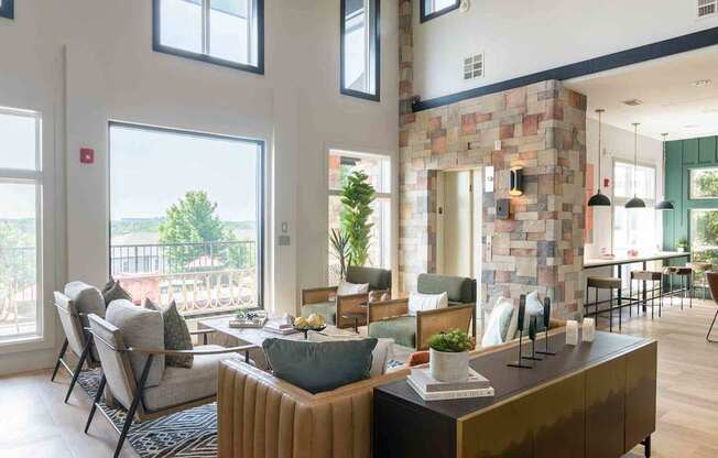 A modern living room with a stone wall and a large window overlooking a deck.