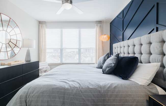 a bedroom with a large bed with pillows and a black and white accent wall