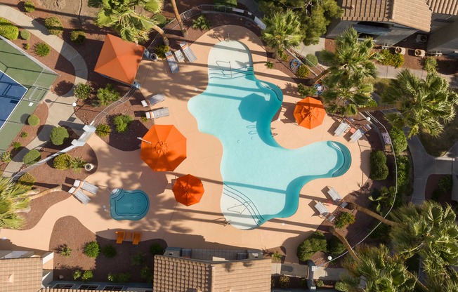 an overhead view of a swimming pool at a resort with umbrellas