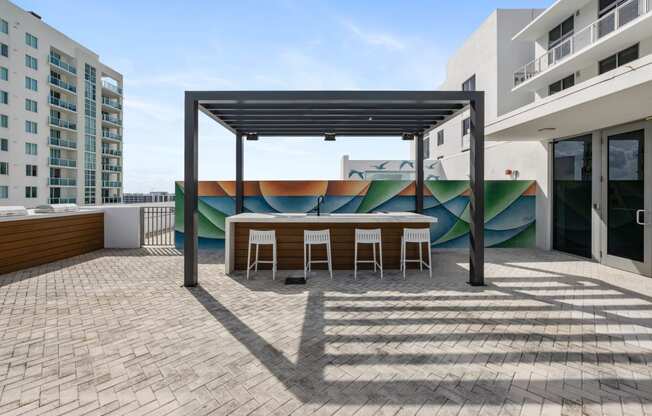a patio with a table and chairs and a mural on the wall