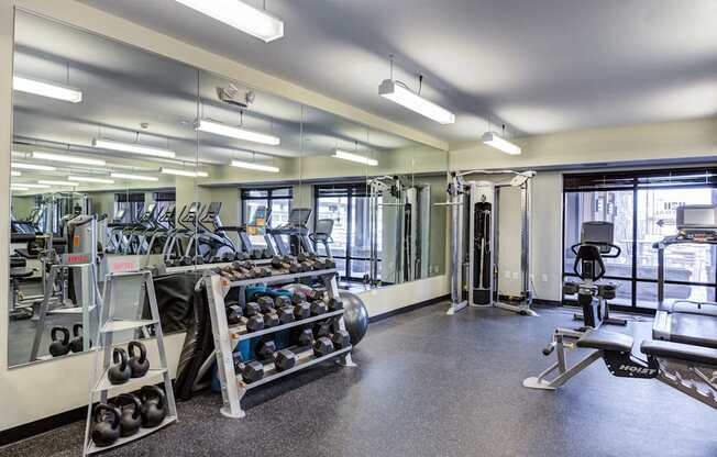 A gym with a variety of equipment including weights and machines.