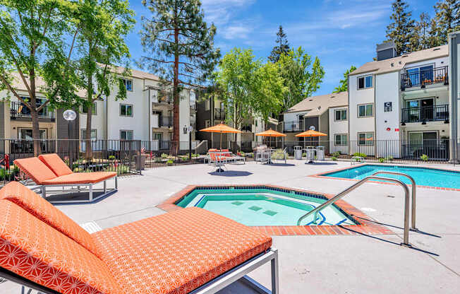 A pool area with orange sun loungers and a small pool.