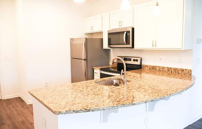 a kitchen with granite counter top and stainless steel appliances