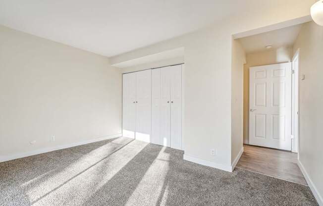 A room with a carpeted floor and a white door.