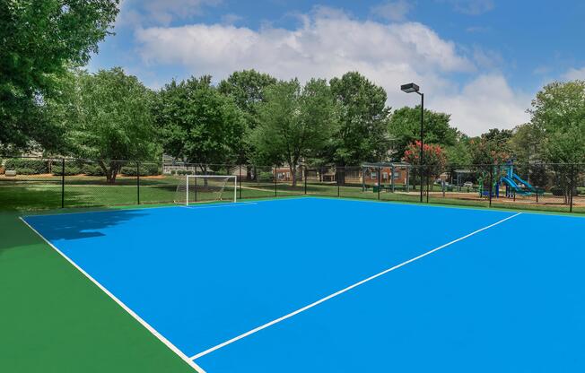 Blue sports court with a soccer net at Ashley Oaks Apartments in Greensboro, North Carolina
