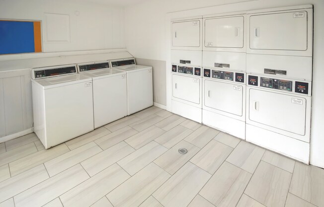 a white laundry room with white appliances and white flooring