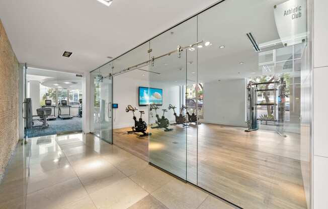 a large lobby with glass walls and a tv on the wall