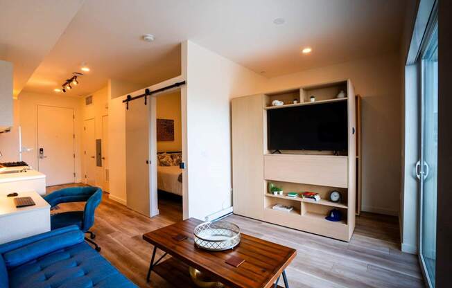 a living room with a blue couch and a television