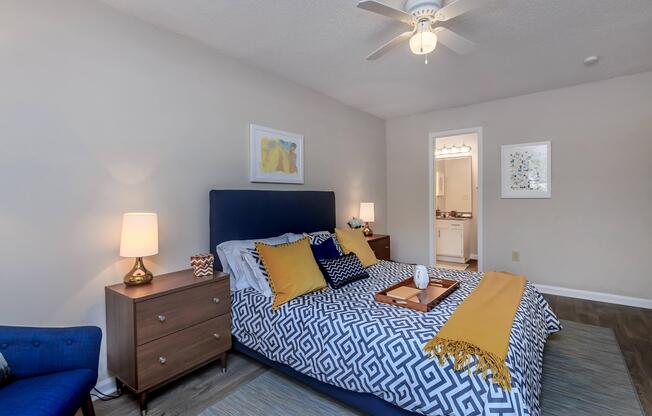 Bedroom with a bed and ceiling fan at Ashley Oaks Apartments in Greensboro, North Carolina