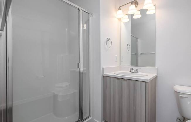 a bathroom with a shower and a sink and a mirror