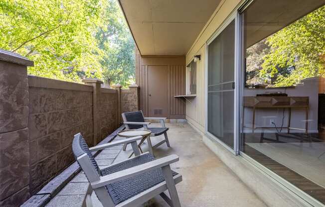 a patio with two chairs and a table on a balcony