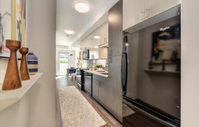 Kitchen Alley with Hardwood Inspired Floor, Rug, Wood Cabinents and Refrigerator