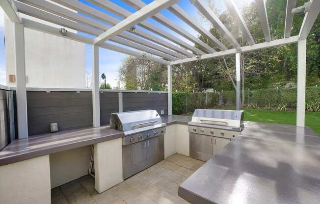 the outdoor kitchen has stainless steel appliances and stainless steel counters