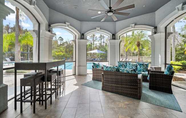 A patio with a table and chairs overlooking a pool.
