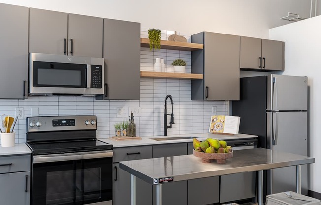 The Mill House floor plan with a modern kitchen with a stove, oven, microwave, and refrigerator at Highland Mill Lofts in Charlotte, NC