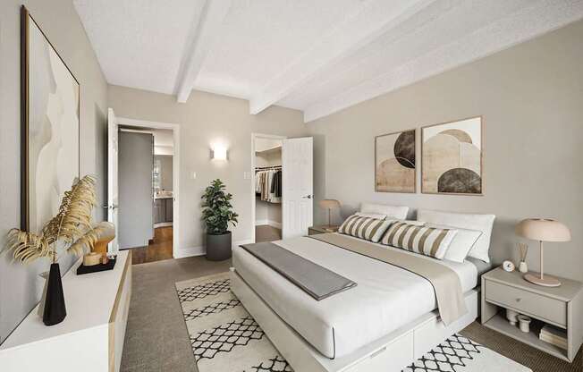 A bedroom with a large bed and a painting on the wall.