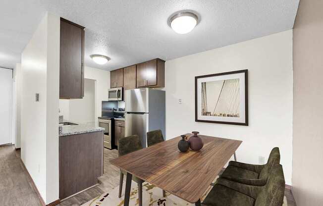A kitchen area with a table and chairs.