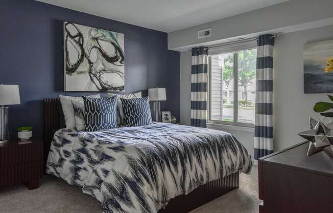 a bedroom with navy blue walls and a bed with blue and white comforter