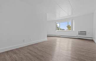 an empty living room with white walls and a window