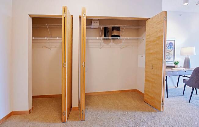 A room with a closet and a desk.