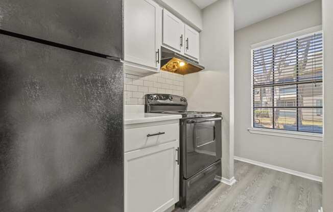 a kitchen with a stove and refrigerator and a window