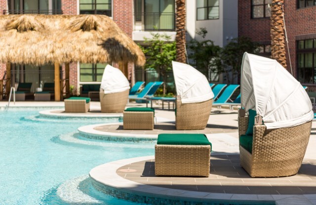 Shaded seating next to pool at Tinsley on the Park | Apartments In Houston