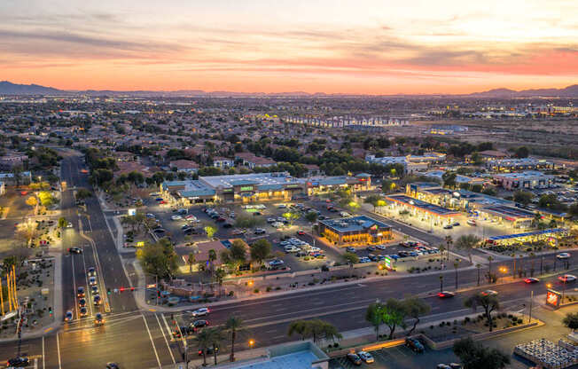 A cityscape at dusk with a view of a highway intersection and buildings.