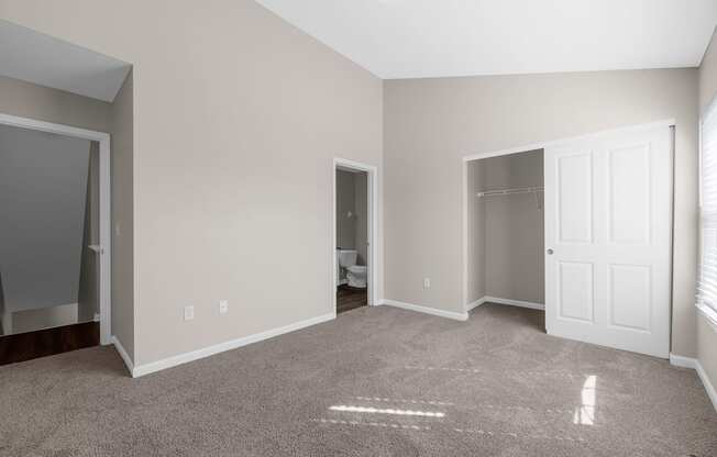 an empty living room with a carpeted floor and a closet at Traditions at Slate Ridge, Reynoldsburg, OH 43068 