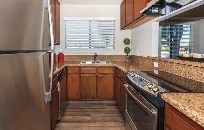 a large kitchen with stainless steel appliances and wooden cabinets