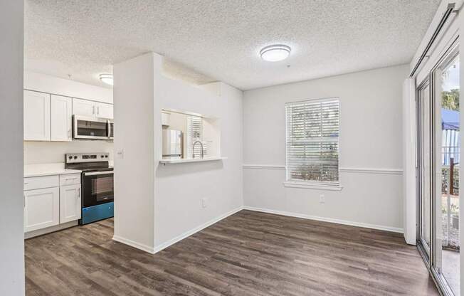 A kitchen with white cabinets and a microwave above the oven.