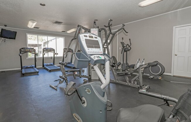 A gym with treadmills, exercise bikes, and other equipment at Laurel Parc apartments in Shreveport, LA.