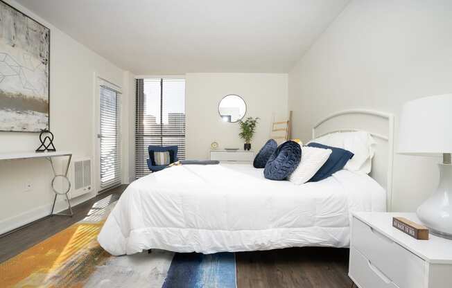 Bedroom with white bed, white night stand and light artwork  on the wall at Vera Cortez Hill, San Diego, 92101