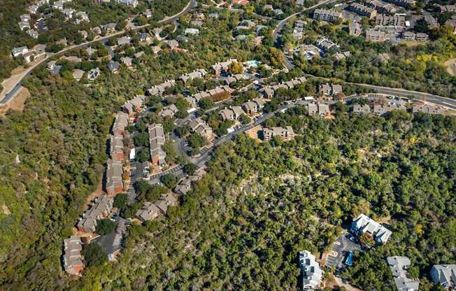 Top view of residential area surrounded by trees at Great Hills, Texas