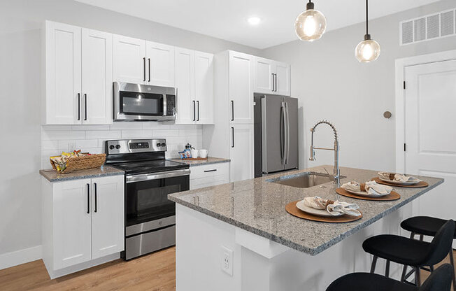 A kitchen with white cabinets and a granite countertop.