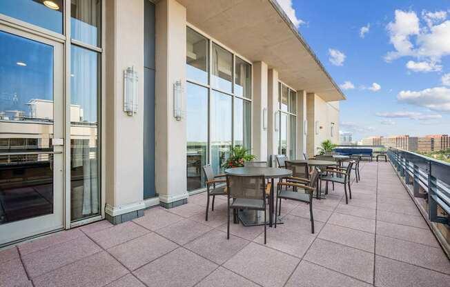 A patio with a table and chairs overlooking a cityscape.