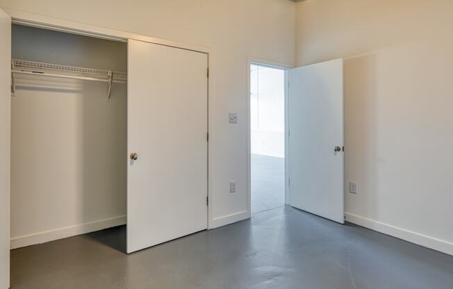 an empty room with a closet and two doors