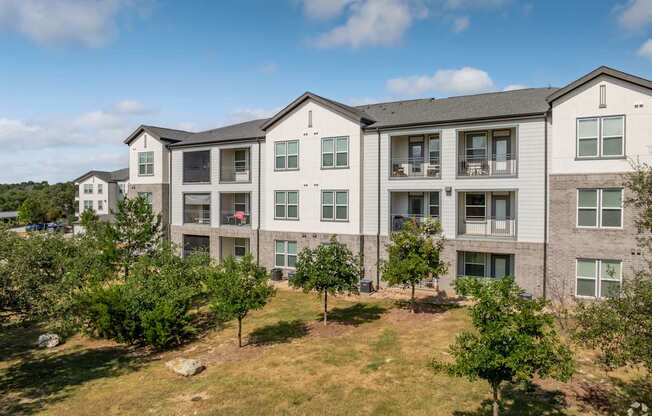 Apartment complex with trees in front.
