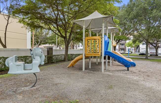 a playground with a swing and slides in a park