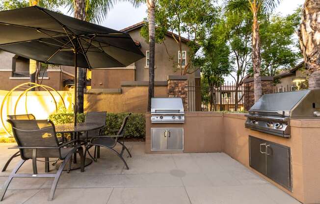 A patio with a table and chairs under an umbrella.
