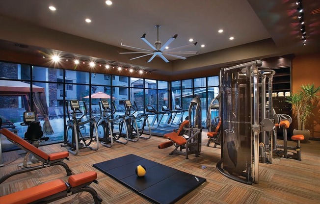 a gym with a lot of exercise equipment and windows