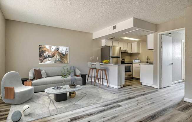 a spacious living room with a kitchen in the background