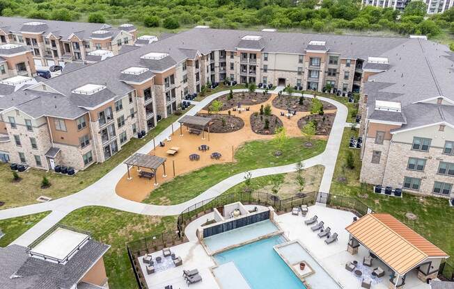 An aerial view of apartment buildings with a pool and a playground.
