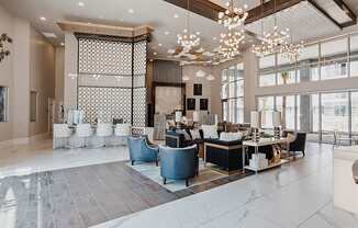 a large lobby with chairs and tables and large windows