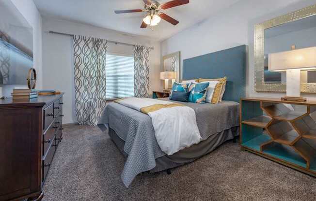 A bedroom with a bed, dresser, and mirror.