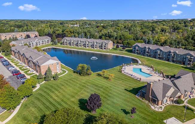 A large apartment community with a pool and a pond at Oak Shores Apartments in Oak Creek, WI