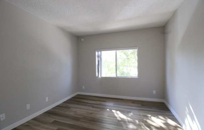 a empty room with wooden floors and a window