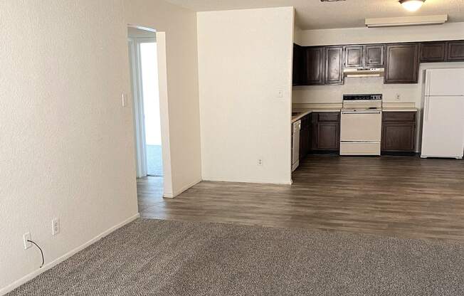A kitchen with white appliances and dark wood cabinets.