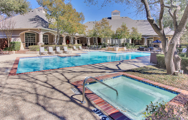 Stunning, tree-lined swimming pool and hot tub with tanning deck and lounge seating