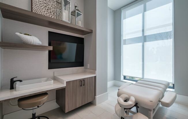 a treatment room at a hospital with a large window and a sink and a chair at Altis Grand Suncoast, Land O' Lakes, FL